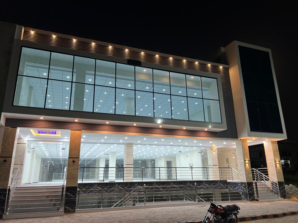 Karachi Office construction - Exterior building perspective at night with bright lights